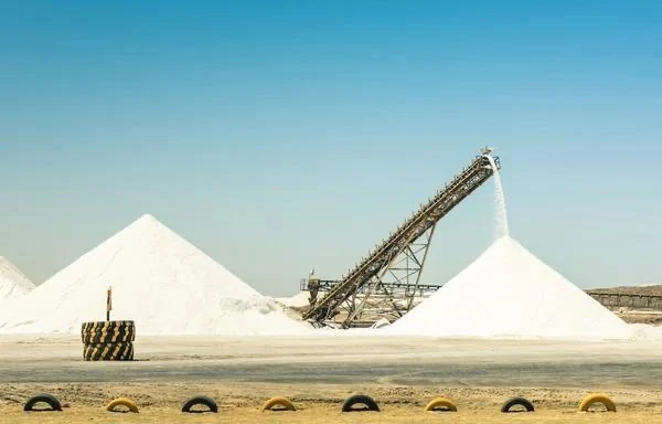 Montes de sal e equipamento transportador em área de produção